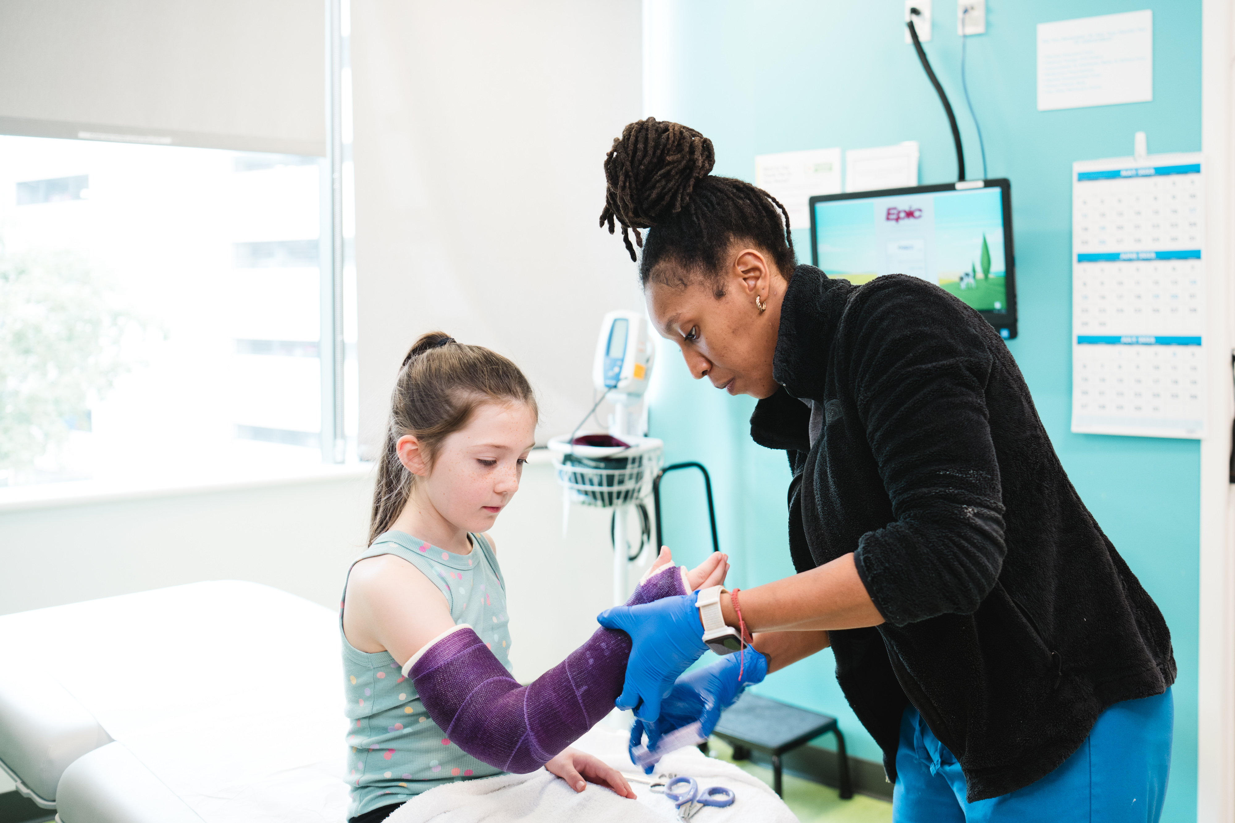 An orthopedic technologist wraps a cast on a patient. An orthopedic technologist wraps a cast on a patient.