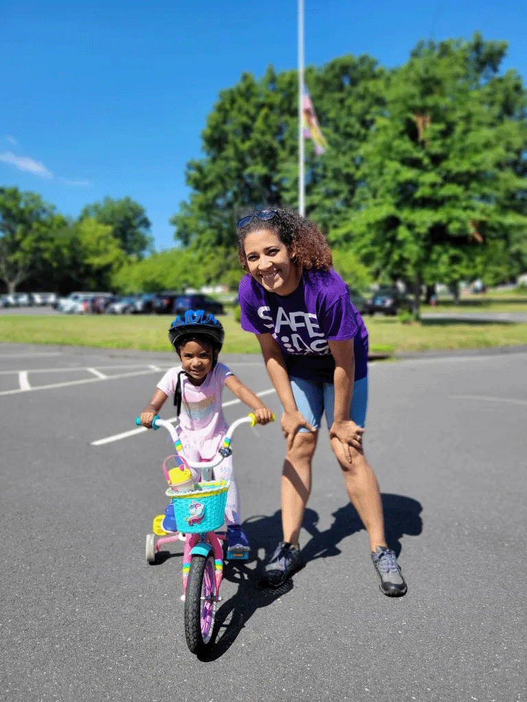 Girl riding a bike with training wheels