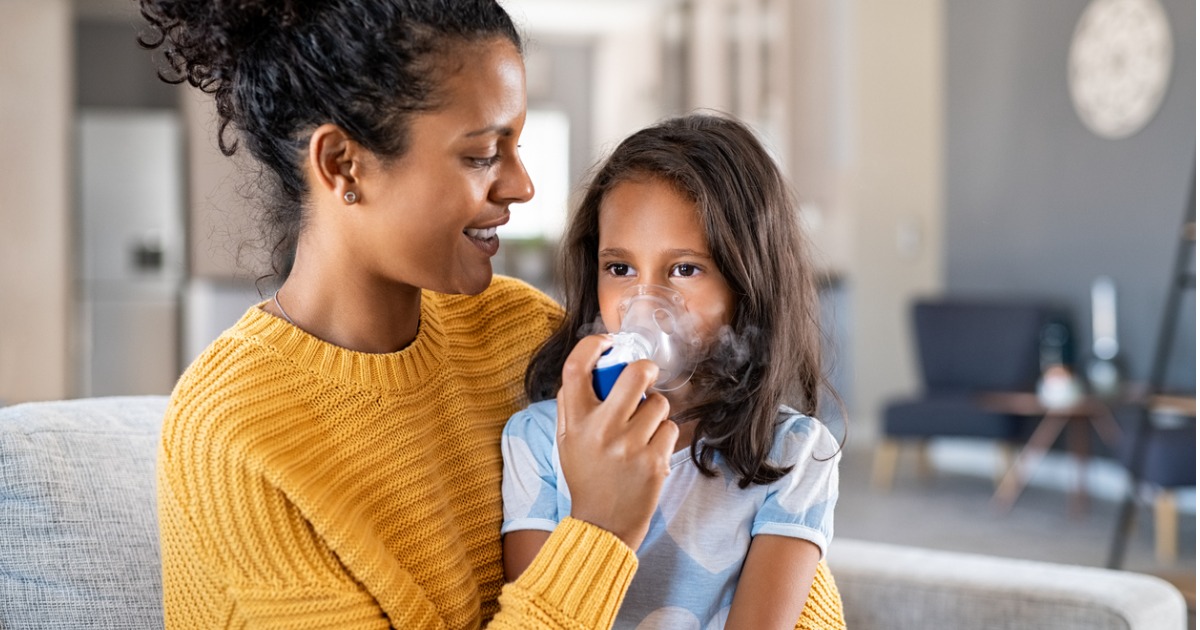 Mother helping her daughter use a nebulizer