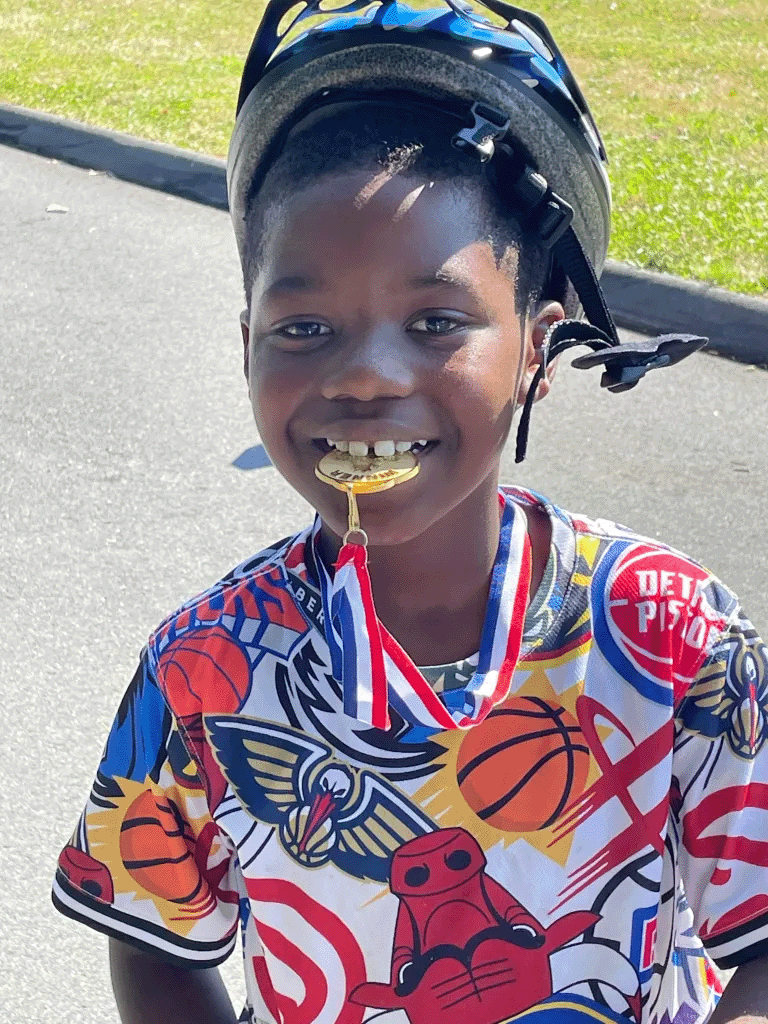 Boy biting a gold medal