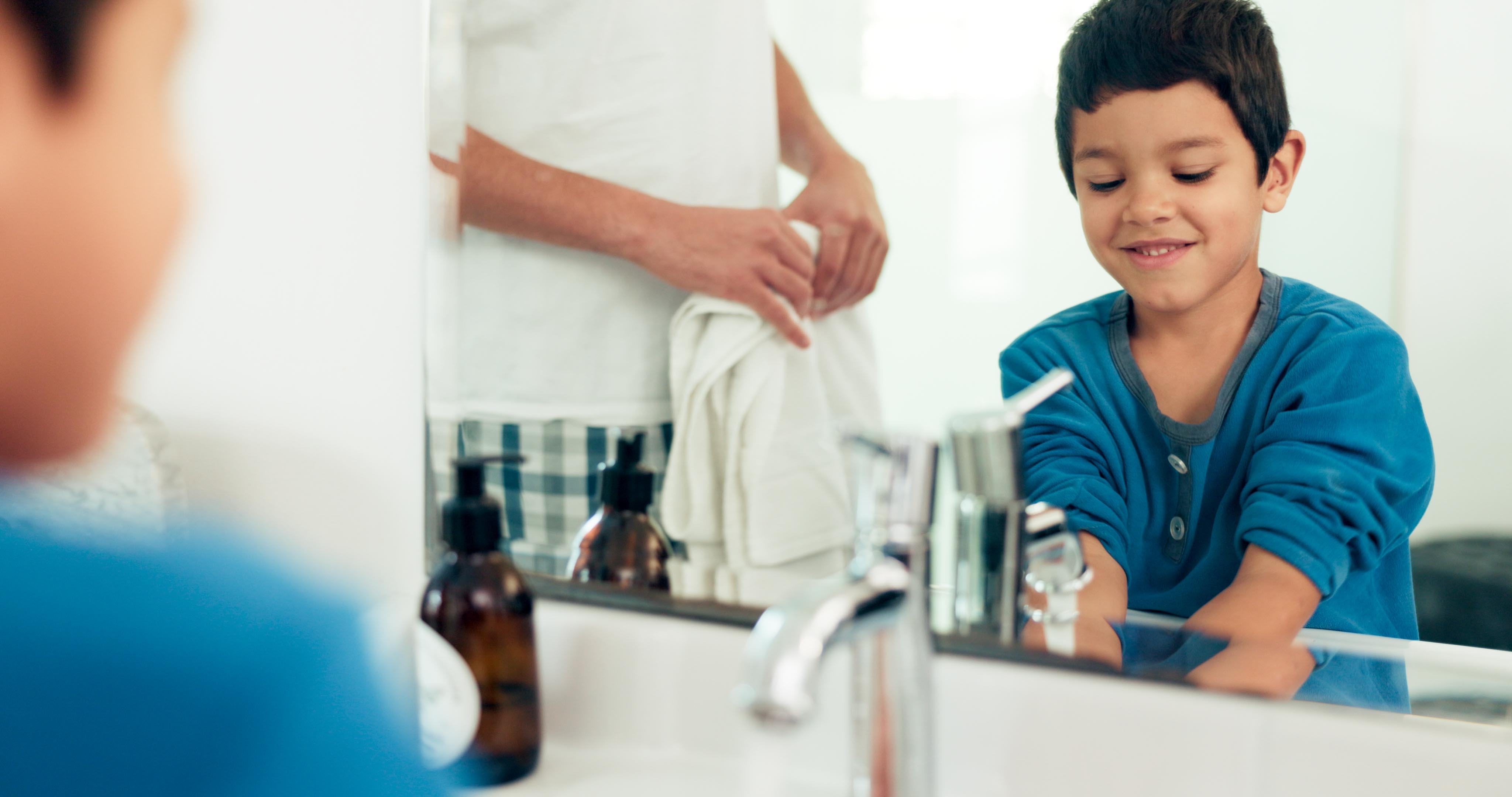 Family, cleaning and boy with hands in sink in bathroom with father and skincare for hygiene at home together