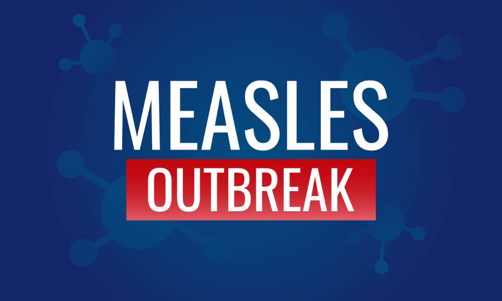 White and red text Measles Outbreak against blue background