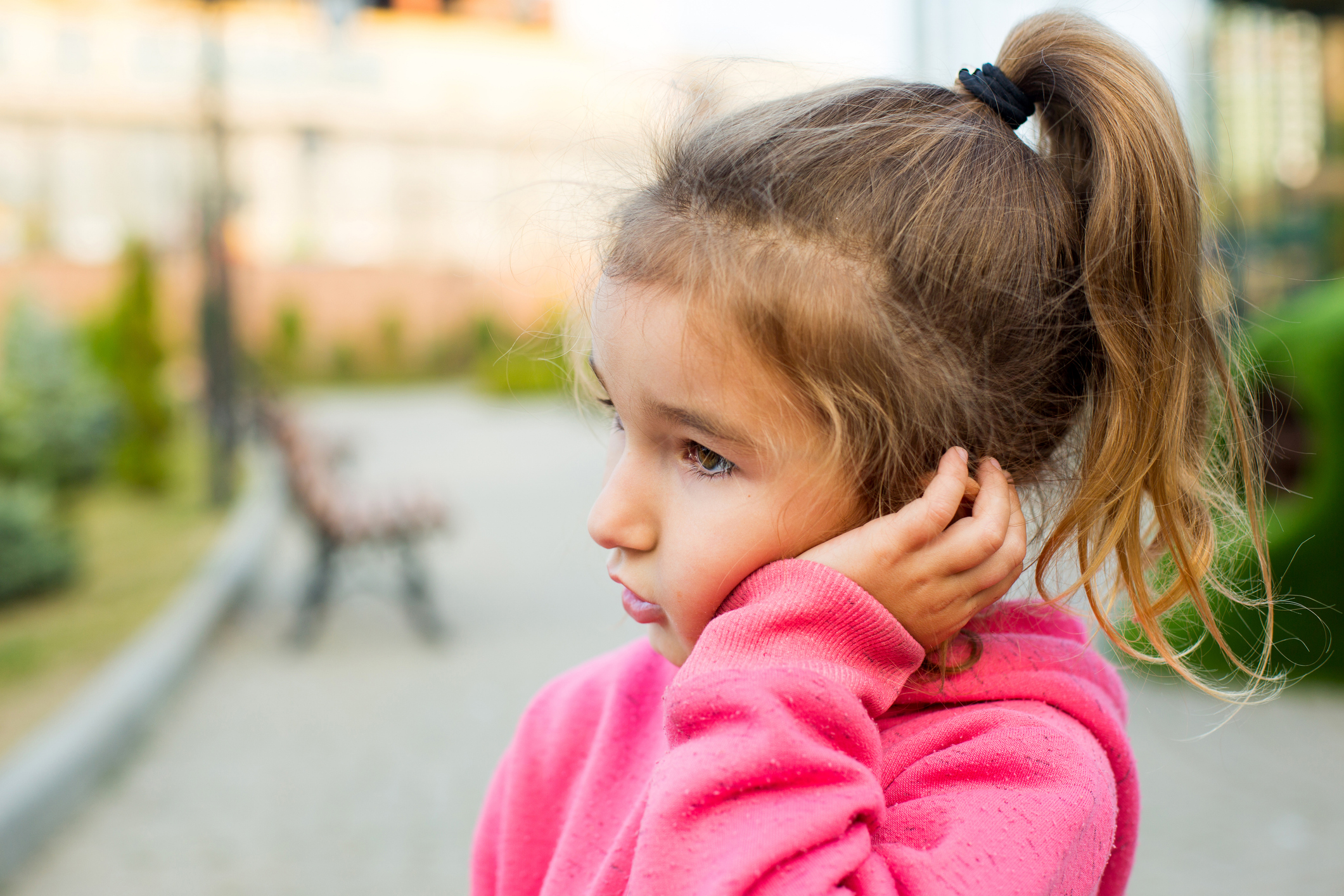 Young girl, around 3, clutching left ear