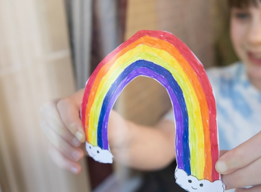 Girl holding a paper rainbow