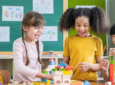 Kids in a classroom playing with wooden blocks