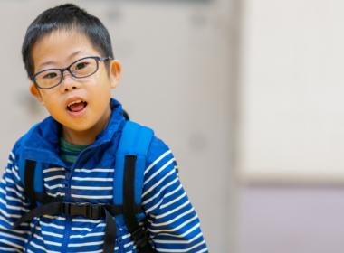 A young boy wearing a backpack