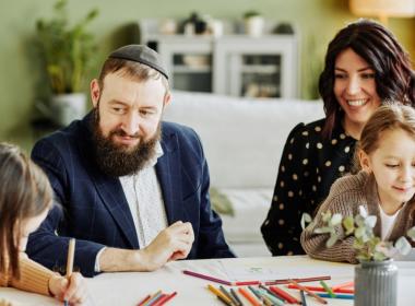 A Jewish family is having fun coloring with their kids