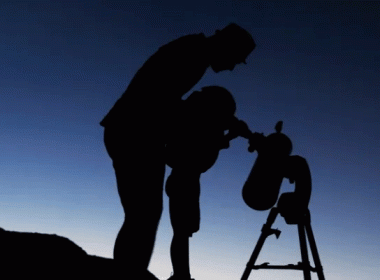 Dad and child looking through a telescope