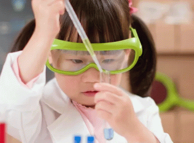 Girl wearing lab coat and goggles