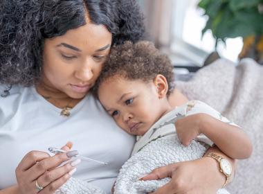 A mother checks her toddlers temperature