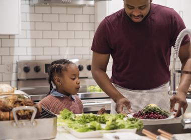 A father and his daughter cook food for Thanksgiving