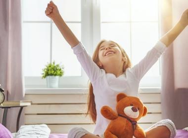 Young girl wakes up and stretches