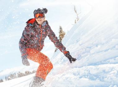 Female snowboarder on slopes, 8 injury prevention tips for skiing and snowboarding