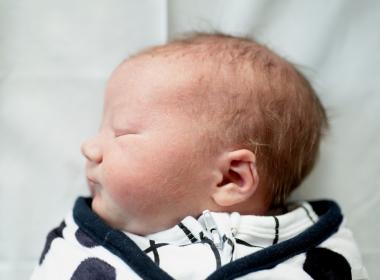 Newborn baby boy sleeping, profile view, ear folded inward