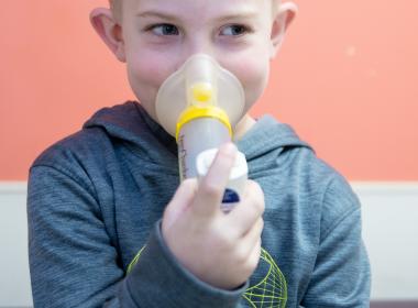 Child taking inhaler. 