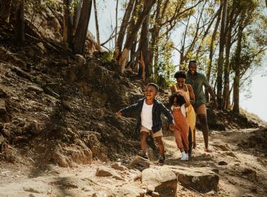 Family of 4 hiking in woods, having fitness challenge