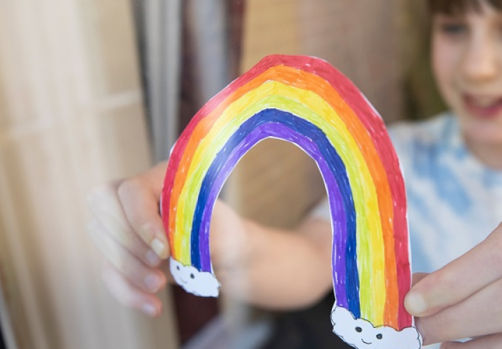 Girl holding a paper rainbow