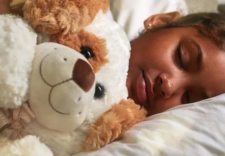 Girl sleeping with a teddy bear