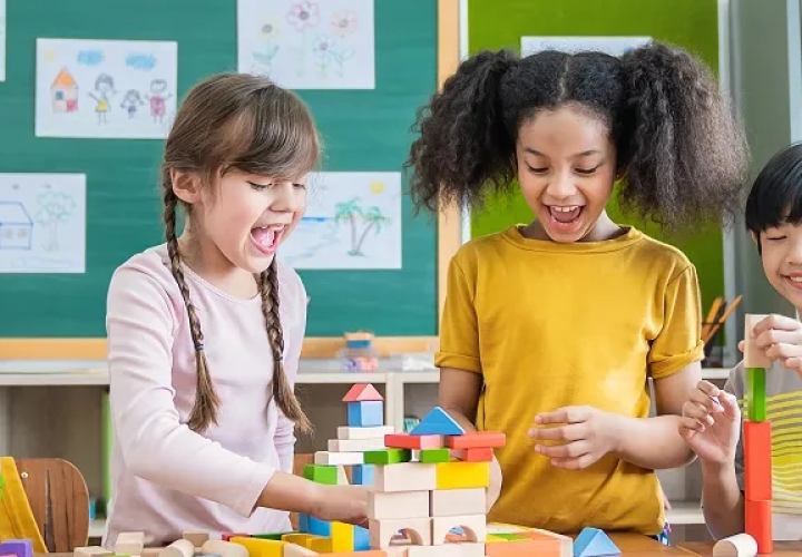 Kids in a classroom playing with wooden blocks