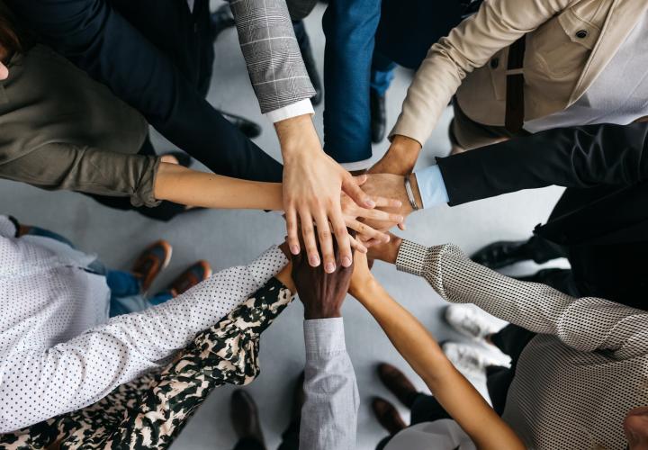 Circle of people with hands in the center on top of each other