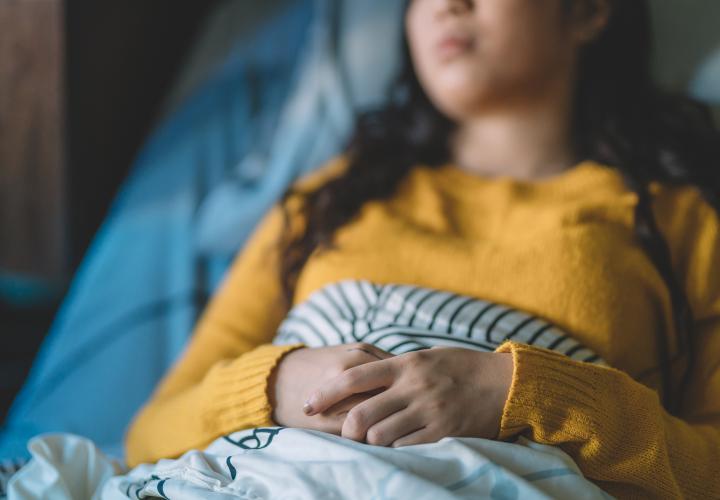 Teen laying in hospital bed