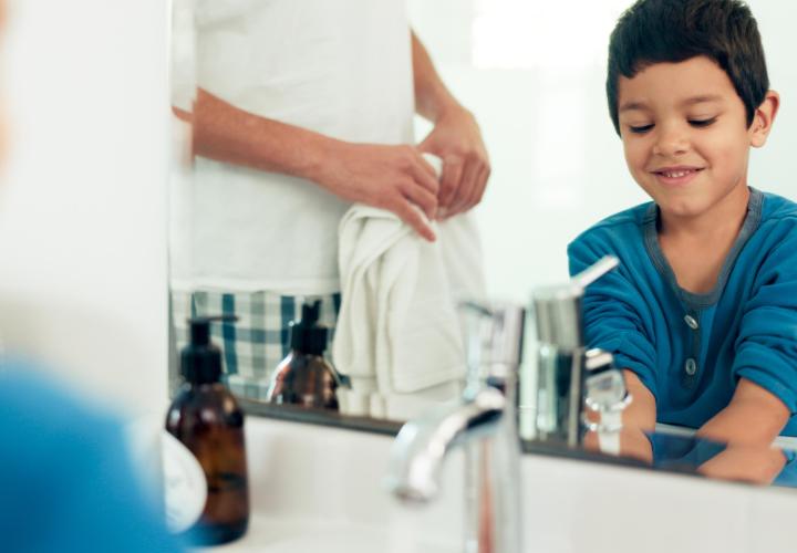 Family, cleaning and boy with hands in sink in bathroom with father and skincare for hygiene at home together