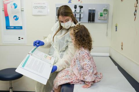 PCD Center Coordinator reviews education materials with young patient