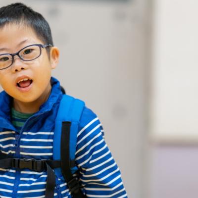 A young boy wearing a backpack