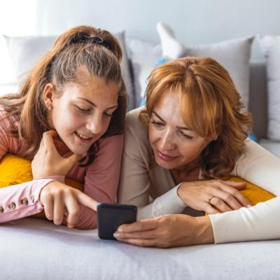 A mother and daughter look at a phone