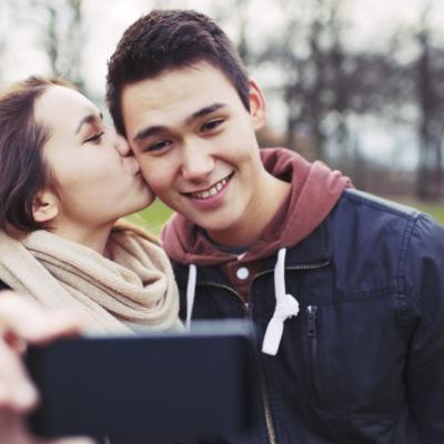 A girl kissing her boyfriend on the cheek