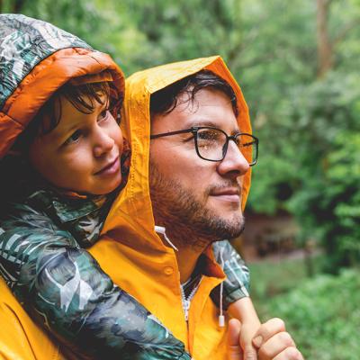 A father and son outside in the rain