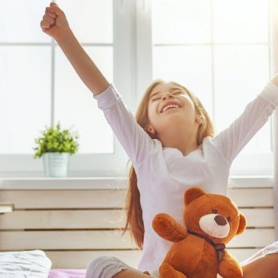 Young girl wakes up and stretches