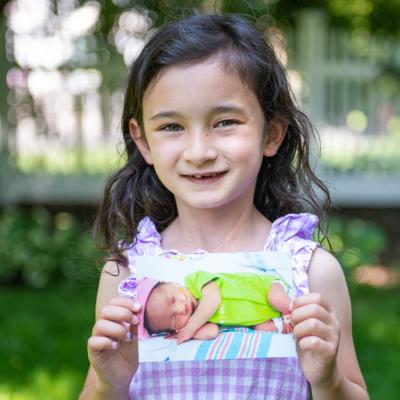 Claire holding a baby photo of herself