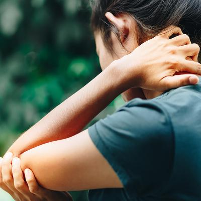 woman holding her elbow in pain