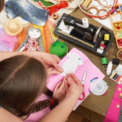 Top-down view of mother and daughter working on a craft project