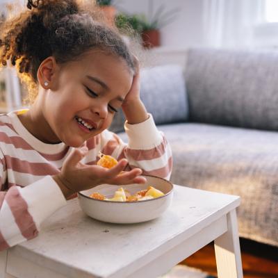 School age child eating a bowl of fruit