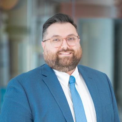 Man with short brown hair and glasses in blue business suit. Thomas Ricci, Chief Financial Officer, Connecticut Children's